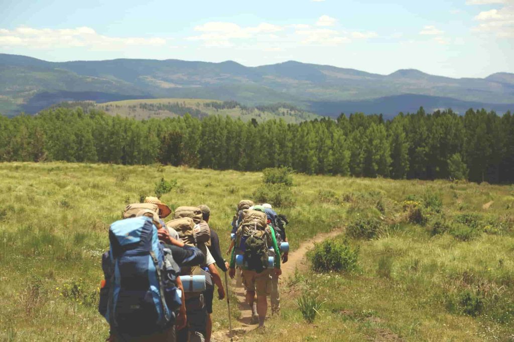 grupo haciendo trekking en el campo-min