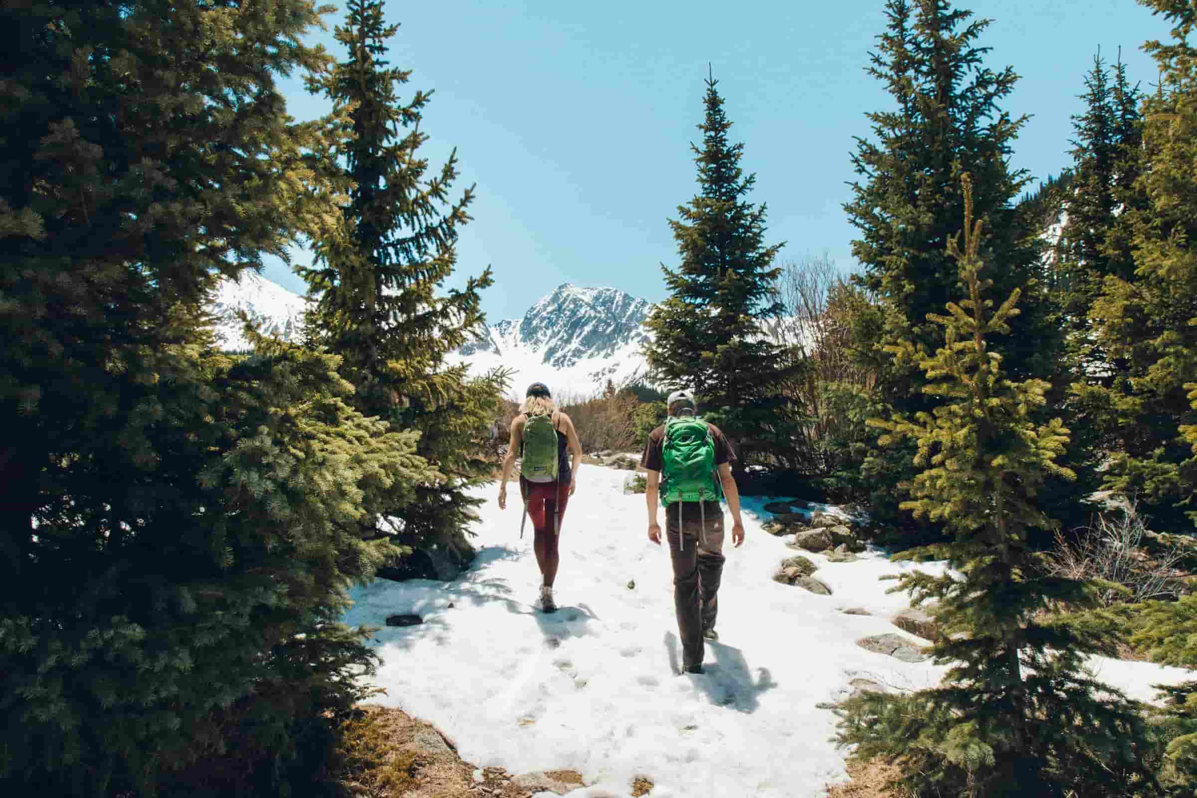 pareja haciendo trekking en montaña-min